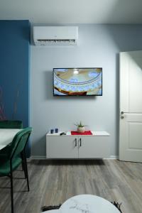 a room with a white table and a blue wall at Travelers' Korça Home in Korçë