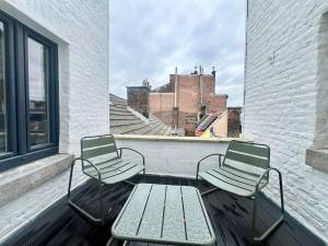 two chairs and a table on a balcony at Duplex chic et spacieux - Hypercentre in Liège