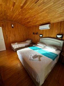 1 dormitorio con 1 cama grande y techo de madera en Garden Pansiyon Çıralı, en Kemer