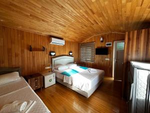 a bedroom with two beds and a wooden ceiling at Garden Pansiyon Çıralı in Kemer