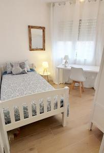 Schlafzimmer mit einem weißen Bett und einem Schreibtisch in der Unterkunft Tarragonaapartments Prim 350 in Reus