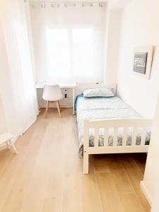 a white bedroom with a bed and a window at Tarragonaapartments Prim 350 in Reus