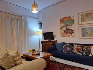 a living room with a couch and a table at GRAND BLUE SUITE DI GIORGIO 10min from Piraeus port in Piraeus