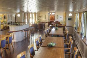 een restaurant met houten tafels en stoelen en een bar bij Botel Sailing Home in Amsterdam