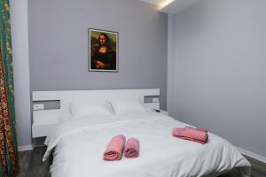 Una cama con dos pares de zapatillas rosas. en Travelers' Korça Home, en Korçë