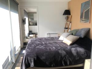 Un dormitorio con una gran cama negra con almohadas en Cocoloclouvigny en Louvigny