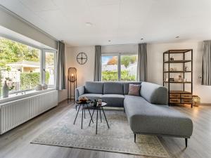 uma sala de estar com um sofá e uma mesa em Charming Holiday Home in Kaatsheuvel near Efteling em Kaatsheuvel