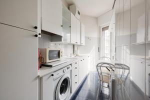 a white laundry room with a washer and dryer at Forlanini - Functional Studio with Balcony! in Milan