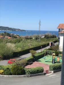 uitzicht op een speeltuin met een speeltuin bij Appartement à côté de la plage avec piscine climatisé in Hendaye