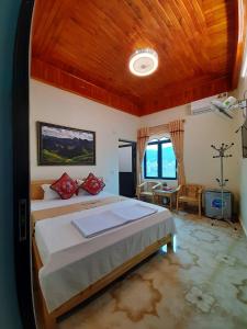 a bedroom with a large bed with a wooden ceiling at Mai's Homestay Dong Van in Dồng Văn