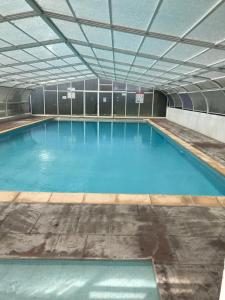 een groot zwembad met blauw water bij Appartement à côté de la plage avec piscine climatisé in Hendaye