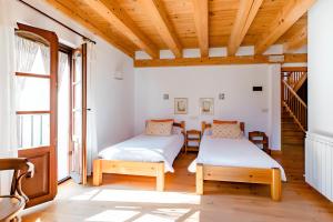two beds in a room with wooden ceilings at Casa Tadeguaz En el corazón de la Jacetania in Fago