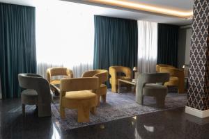 a waiting room with chairs and tables and a window at Hotel Santa Maura in Rome