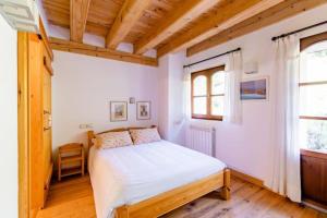 ein Schlafzimmer mit einem Bett in einem Zimmer mit Holzdecken in der Unterkunft Casa Tadeguaz in Fago