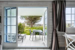 an open door to a patio with a table and chairs at Vue et face Golf Port Bourgenay in Talmont-Saint-Hilaire