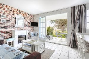 a living room with a brick wall at Vue et face Golf Port Bourgenay in Talmont-Saint-Hilaire