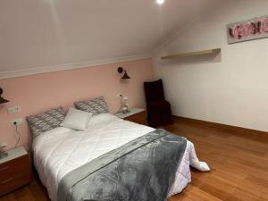 ein Schlafzimmer mit einem großen Bett und Holzboden in der Unterkunft Apartamento CASA MARIA in Rianjo