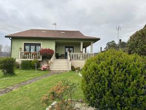 ein kleines grünes Haus mit einer Veranda und einer Treppe in der Unterkunft Apartamento CASA MARIA in Rianjo