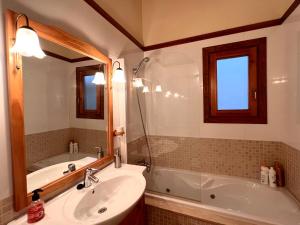 a bathroom with a sink and a tub and a mirror at Dúplex el Torrent in Sort