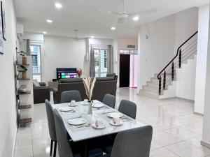a dining table and chairs in a living room at 4Bedroom Simfoni Langkawi Homestay in Kuah