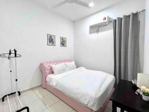 a small bedroom with a pink bed and a table at 4Bedroom Simfoni Langkawi Homestay in Kuah