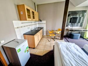 małą kuchnię z lodówką i stołem w obiekcie Family hotel Maxim w mieście Beroun