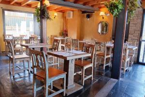 una sala da pranzo con tavoli e sedie in legno di Rustik Hostal Rural a Molinaseca