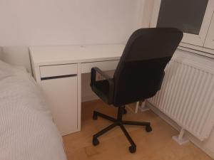 a black office chair sitting next to a desk at Bright and cozy room next to the airport in Kampenhout