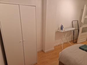 a bedroom with a white cabinet next to a bed at Bright and cozy room next to the airport petit in Kampenhout