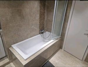 a white bath tub in a bathroom with a shower at Bright and cozy room next to the airport in Kampenhout