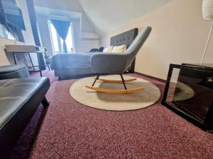 ein Wohnzimmer mit einem Stuhl und einem Sofa in der Unterkunft Family hotel Maxim in Beroun