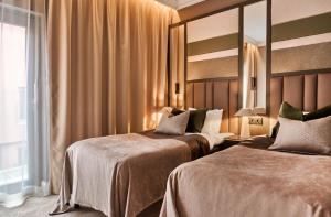 a hotel room with two beds and a mirror at Opus XVI, a member of Small Luxury Hotels of The World in Bergen