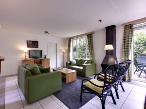 - un salon avec un canapé et une table dans l'établissement Cozy holiday home with a garden near Zwolle, à Dalfsen