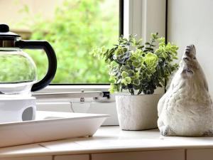 un rebord de fenêtre avec une plante en pot et un vase dans l'établissement Cozy holiday home with a garden near Zwolle, à Dalfsen