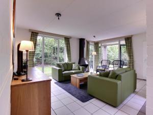 - un salon avec deux canapés et une télévision dans l'établissement Cozy holiday home with a garden near Zwolle, à Dalfsen
