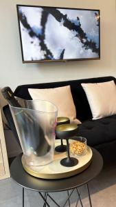 a table in a living room with a black couch at Studio de l'Avenue in Spa