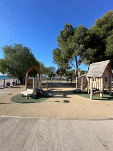 un parque infantil con tobogán y una casa pequeña en Athens Sea Front Apartment - Athenian Riviera en Varkiza