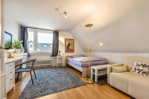 um quarto com uma cama, uma secretária e um sofá em Freundliche Ferienwohnung in Lemgo em Lemgo