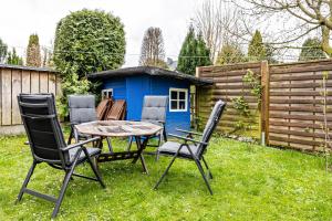 uma mesa e cadeiras num quintal com um barracão azul em Freundliche Ferienwohnung in Lemgo em Lemgo