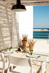una sala da pranzo con tavolo e sedie bianchi di Casa Solomare by Momò Apulia a Monopoli
