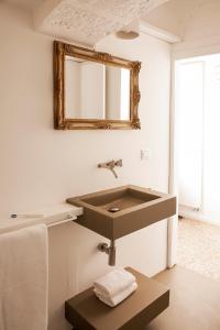bagno con lavandino e specchio a parete di Casa Solomare by Momò Apulia a Monopoli