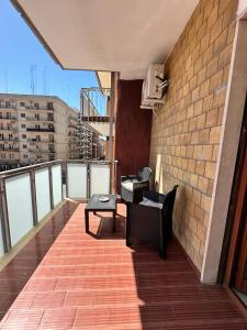 einen Balkon mit Stühlen und einem Tisch auf einem Gebäude in der Unterkunft Gli Amici della Puglia in Taranto