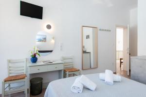 a bedroom with a bed and a desk and a mirror at Simeon Rooms & Apartments in Kamares