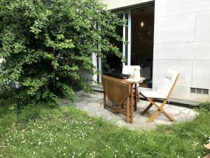 eine Terrasse mit einem Tisch, einem Stuhl und einem Laptop in der Unterkunft Studio agréable & charmant + WI-FI in Neuilly-sur-Seine