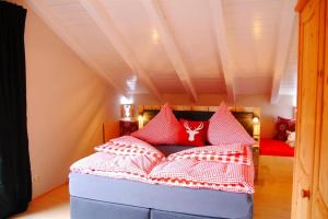 Un dormitorio con una cama con almohadas rojas. en Ferienhaus Bergzauber im Oberallgäu, en Blaichach