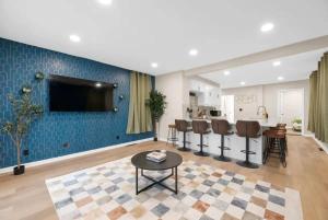 ein Wohnzimmer mit einer blauen Wand und einem TV in der Unterkunft Best Location Sleeps 12 Hot Tub Free Parking in Columbus