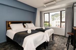 2 camas en una habitación con ventana en Haka House Wellington, en Wellington
