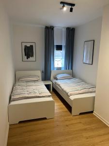 two beds in a small room with a window at Apartments zum Wildgehege in Siegen