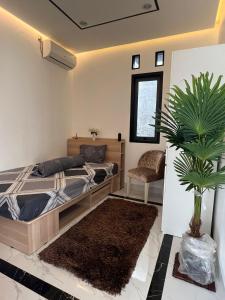 a bedroom with a bed and a potted plant at Belle's WMR Guest House in Jakarta