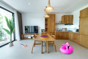 cocina con mesa de madera y sillas rosas en Premier Umalas Villas en Kerobokan